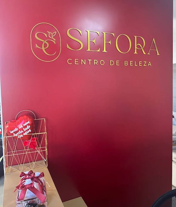 Parede vinho com o logotipo dourado do Sefora Centro de Beleza